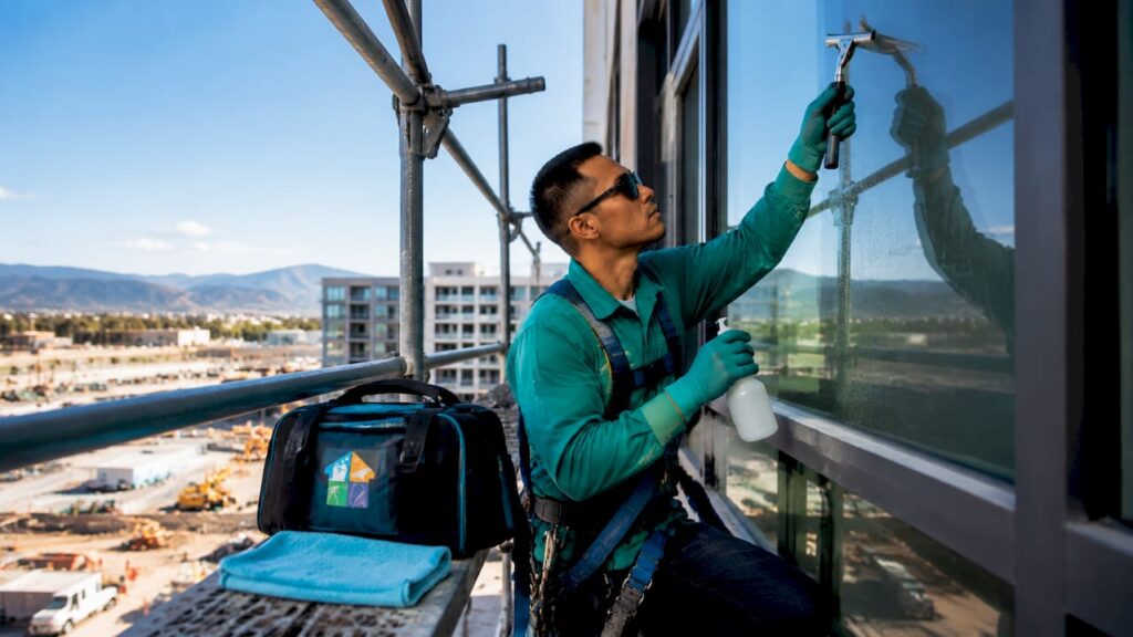 Window cleaner inspecting construction site glass